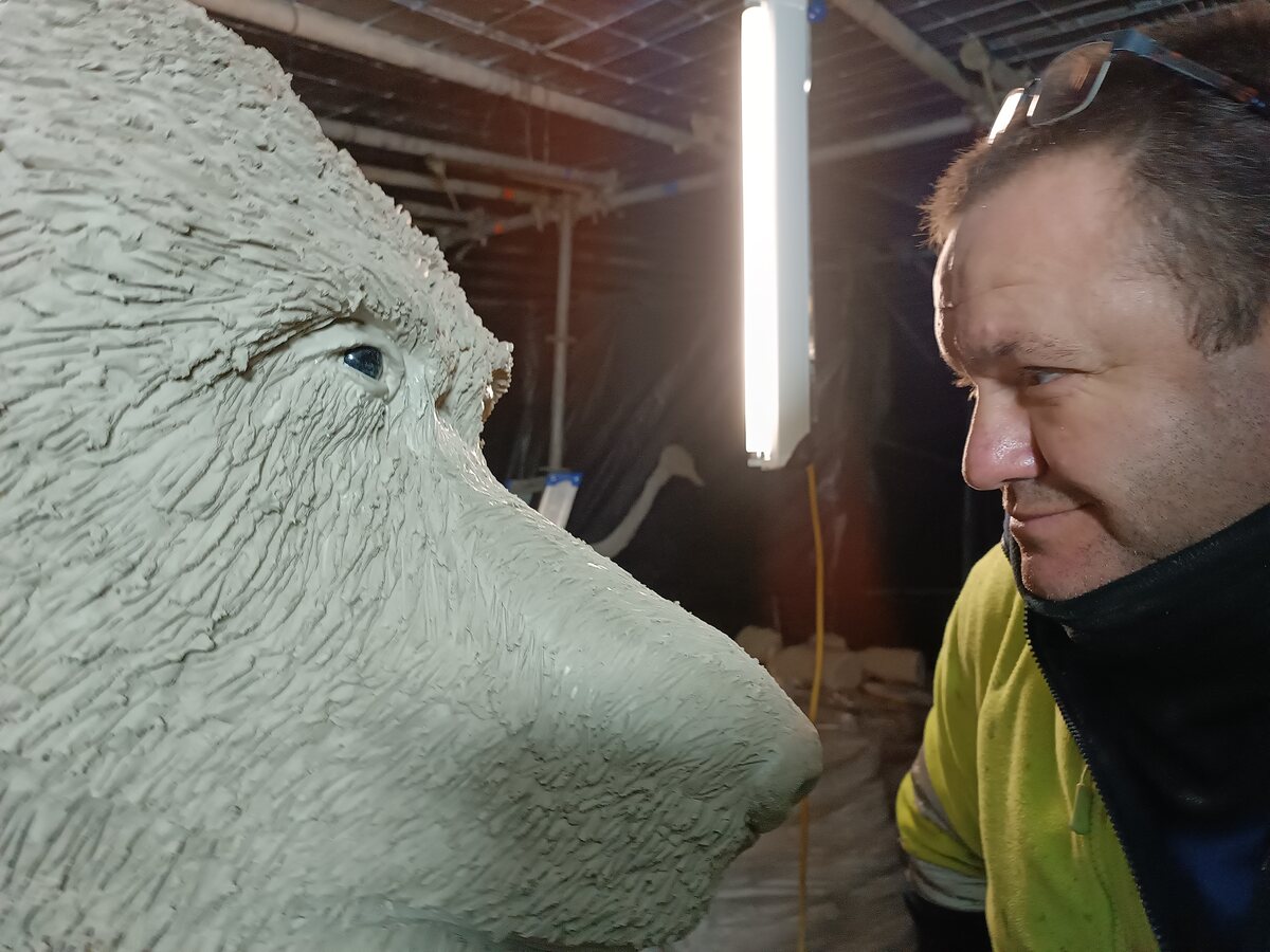 Close work on a sculpted face, showing hands-on craftsmanship
