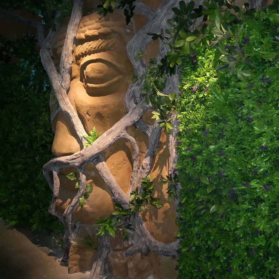 Sculpted figure integrated with planting and natural textures