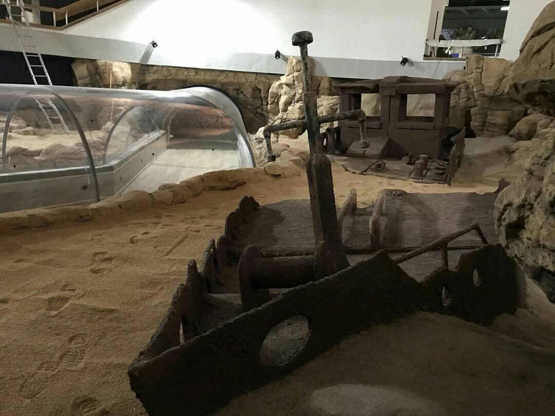 Themed anchor and timber wreckage on a sandy floor at Klaipeda Aquarium